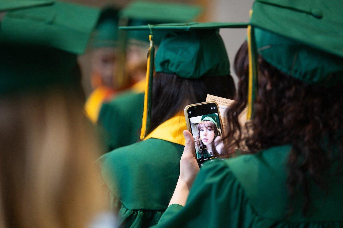 A student takes a selfie before commencement